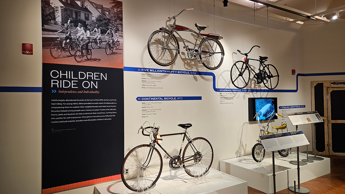 a museum exhibit featuring four bicycles mounted to the walls