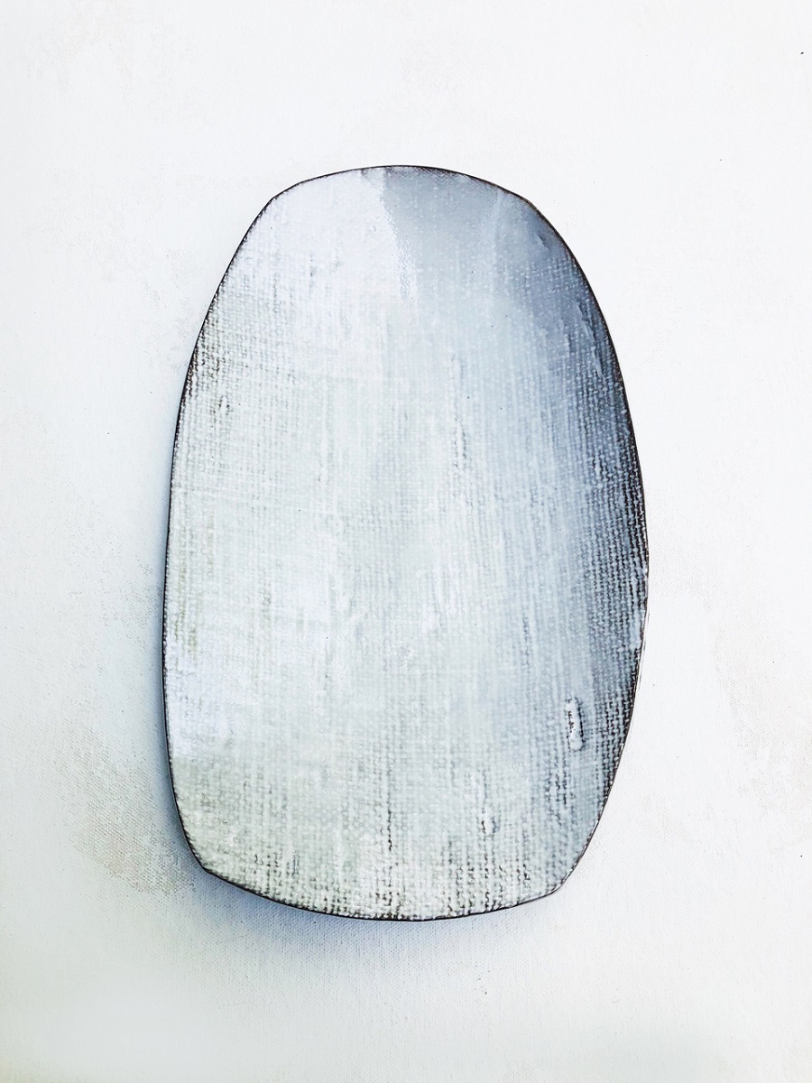 White rectangular platter with rounded corners with slightly visible dark mesh pattern underneath