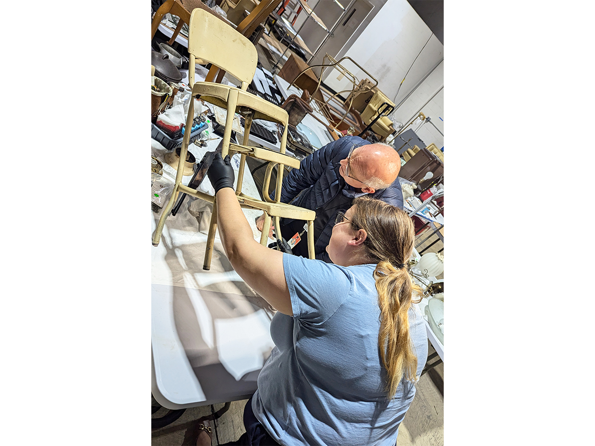 Curator of Decorative Arts Charles Sable consults with Conservator Louise Beck on conservation treatment of a Cosco  chair with steps used in the Jackson Family Home kitchen. / Photograph by Staff of The Henry Ford.