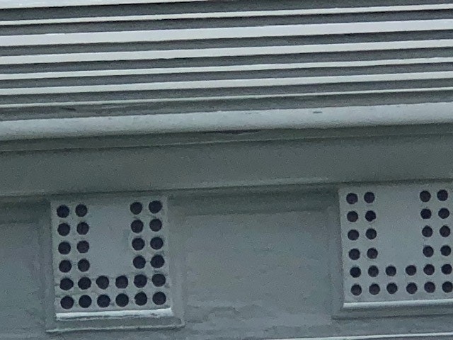 Mutules on the Webster House Architectural elements of white boxes with round holes in a