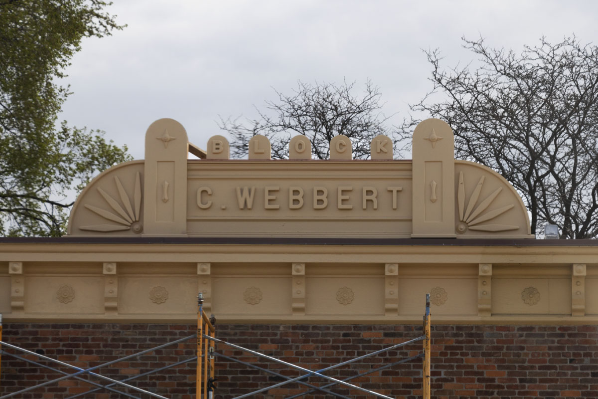 The C. Webbert Block sign atop Wright Cycle Shop in Greenfield Village Building roof with large sign with decorative elements and text reading