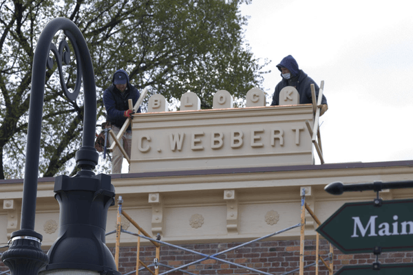Installing and securing the C. Webbert Block sign GIF cycling through several images of people working with a sign on a rooftop