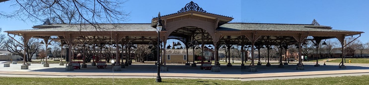 Panoramic image of large, open-sided building with many support beams