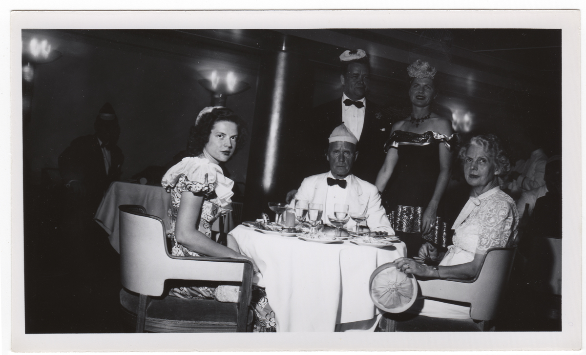 Catherine Roddis with her daughter Augusta and husband Hamilton Black-and-white photo of three people seated at a table look toward the camera; two more people stand behind the table