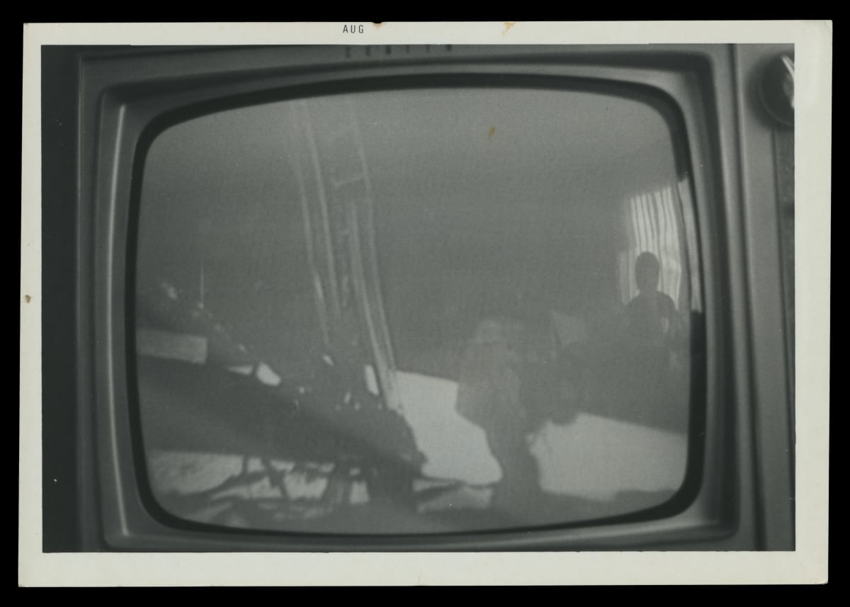 Home Television Broadcast of NASA's Apollo 11 Moon Landing, July 20, 1969 Black-and-white photograph of the moon landing on a TV set with watchers reflected in the glass