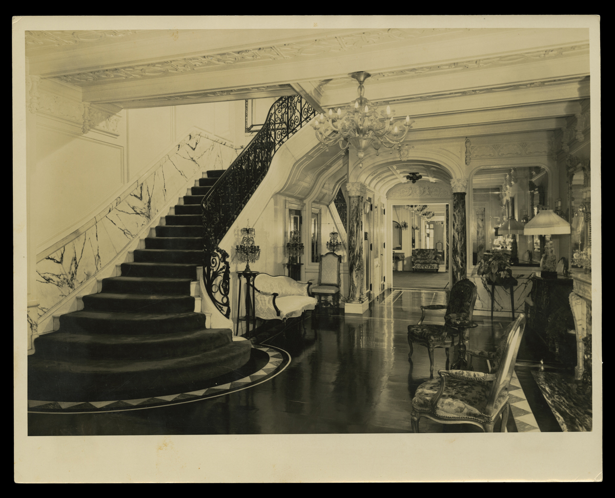 Interior of upscale mansion with sweeping staircase and luxurious furnishings