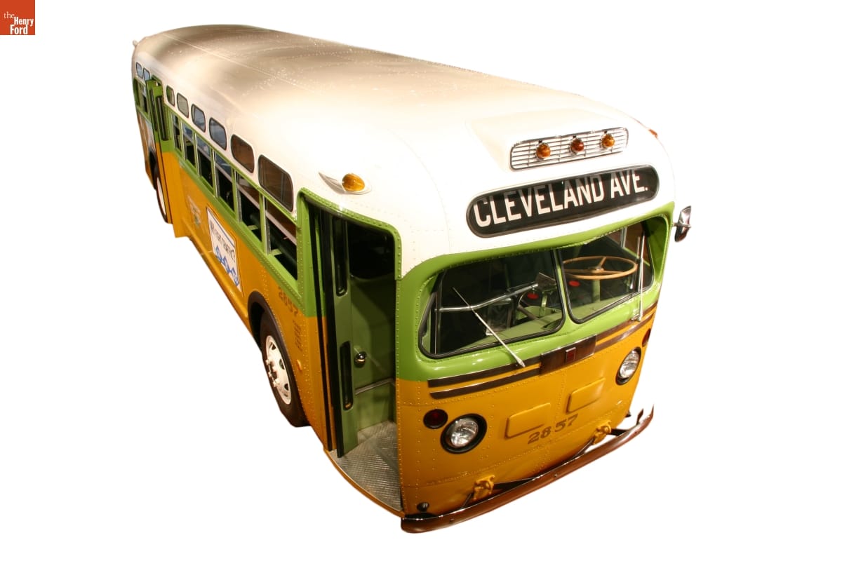 Lime green, mustard yellow, and white bus with sign 