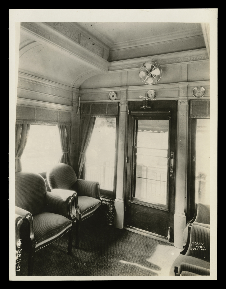 Interior of Henry Ford's Private Railroad Car, Black-and-white photo of room showing two chairs, windows, and glass door