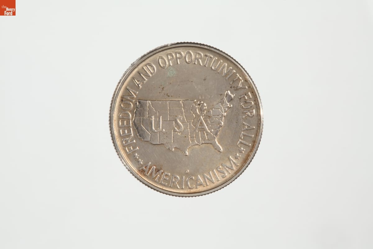 Silver coin with map of United States and text