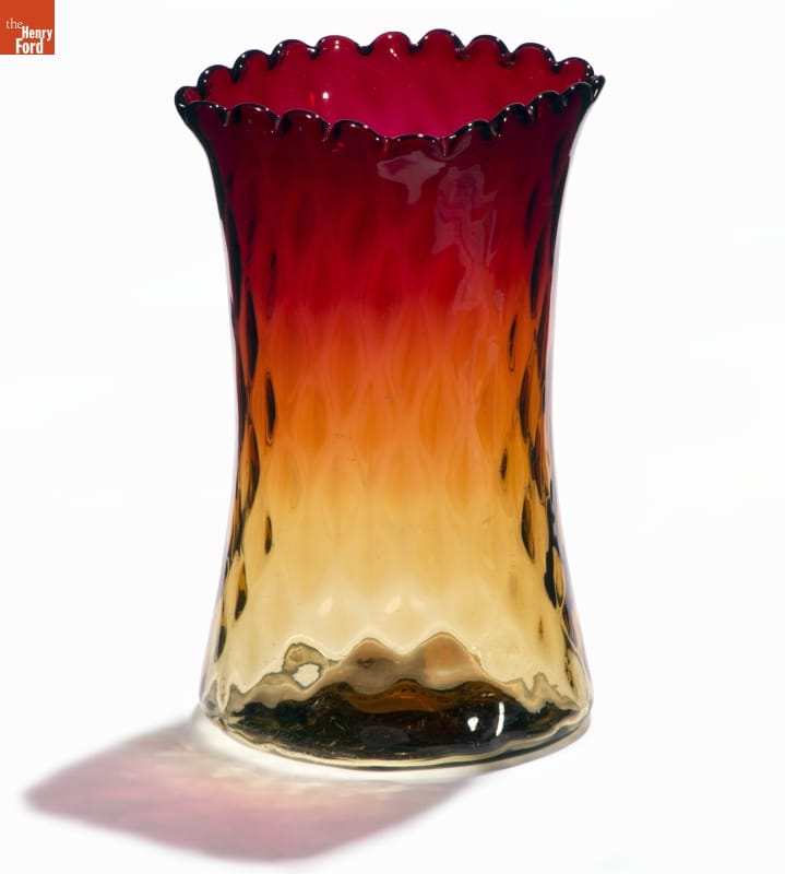 Glass vase with slightly indented sides and a diamond-patterned texture, yellow at bottom morphing to dark red at top