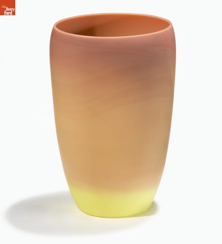 Opaque glass cup-shaped vase, with color morphing from yellow at the bottom to rust at the top