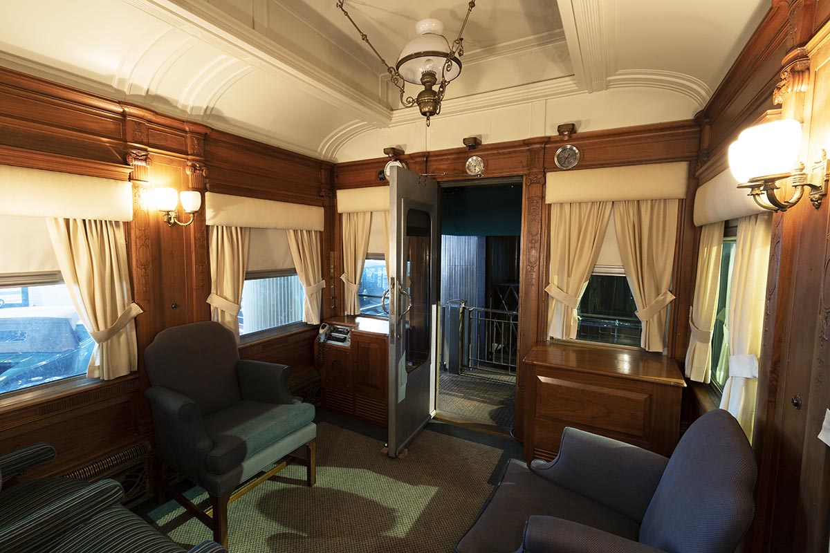 Henry Ford's Private Railroad Car Room interior with arched ceiling, blue upholstered furniture, and wood paneling