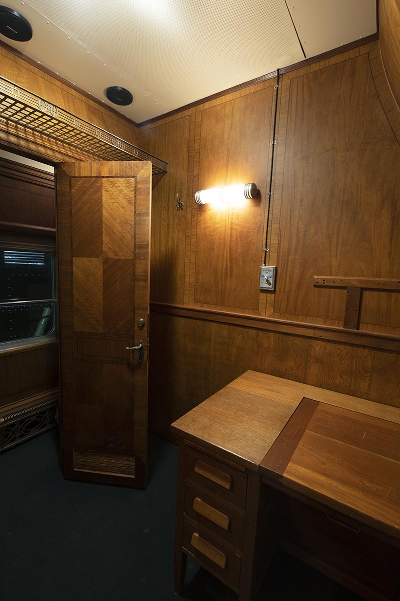 Interior of wood-paneled room containing a wooden desk