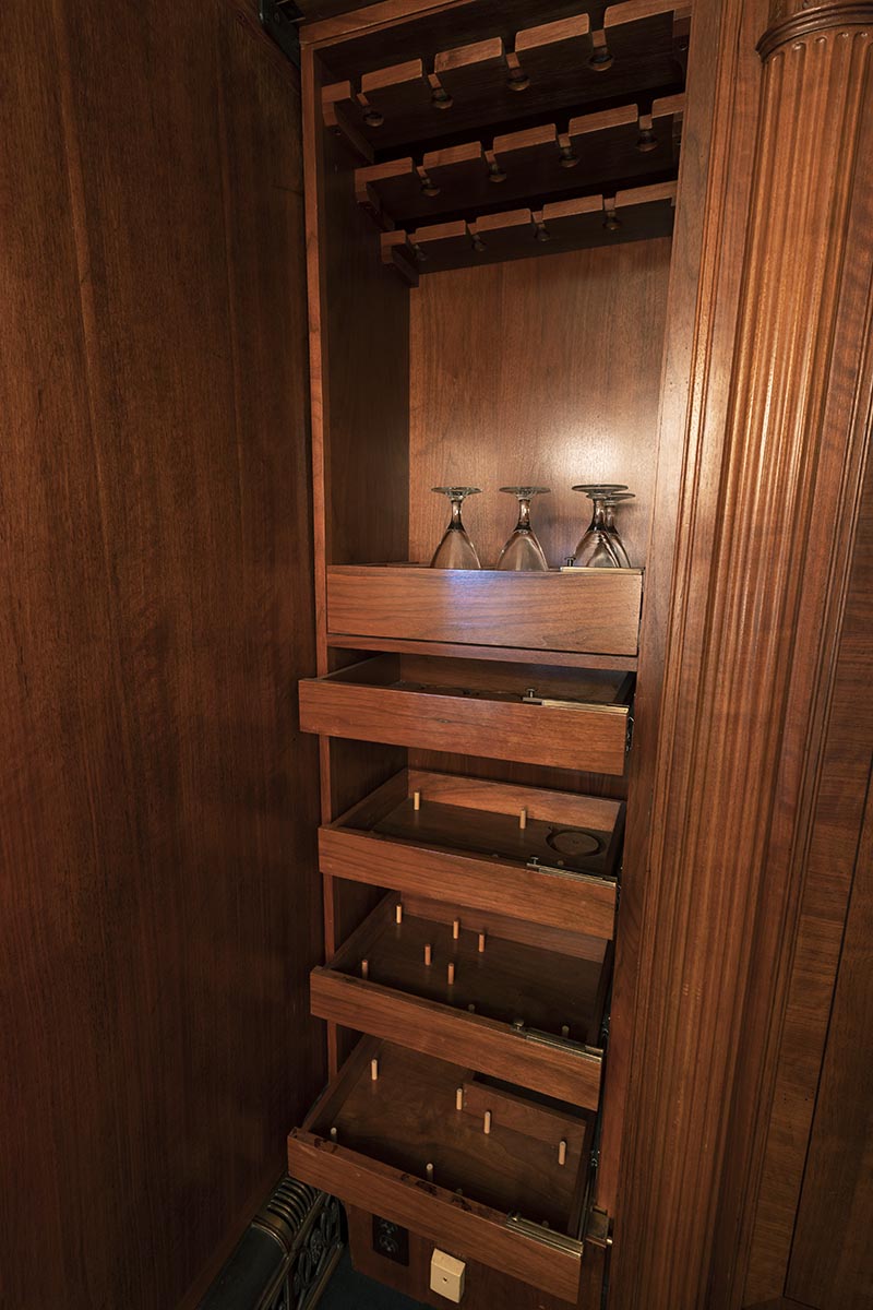 Henry Ford's Private Railroad Car Wooden shelving with pegs on some shelves and a few glasses on top shelf