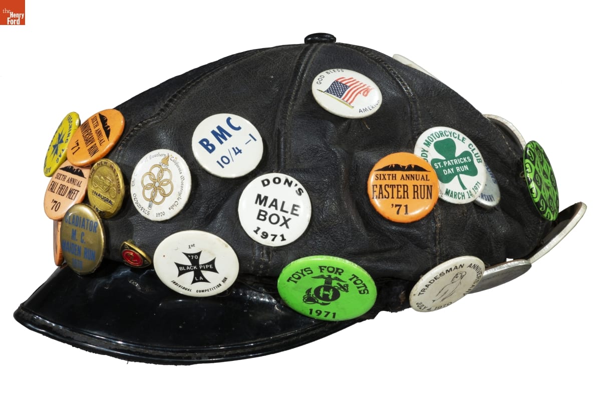 Black motorcycle covered with more than a dozen pins and buttons