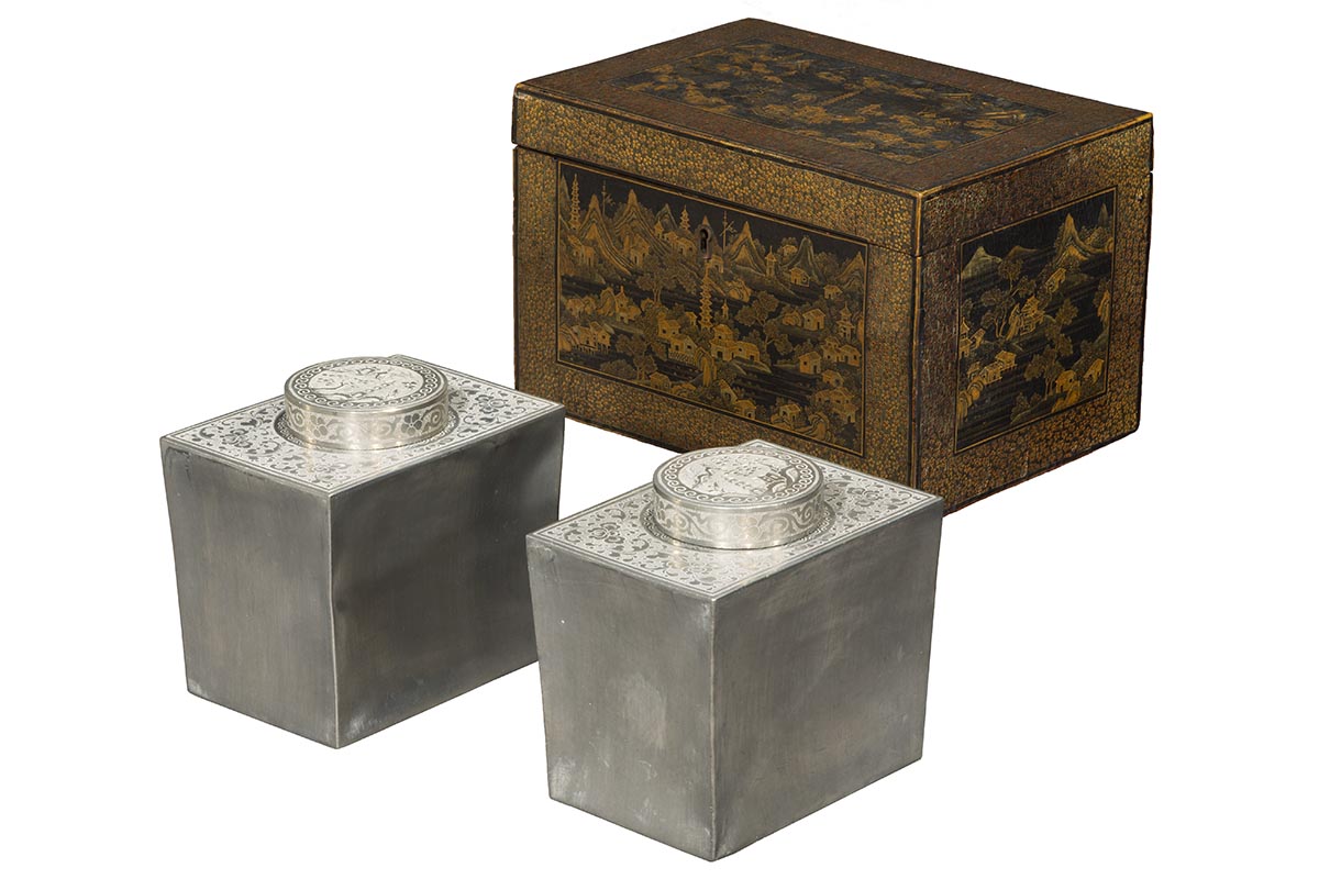 Tea Box, 1800-1840 Lacquered box in shades of brown and black with scene of houses and stupa; two silver cannisters with decorated tops sit in front of it