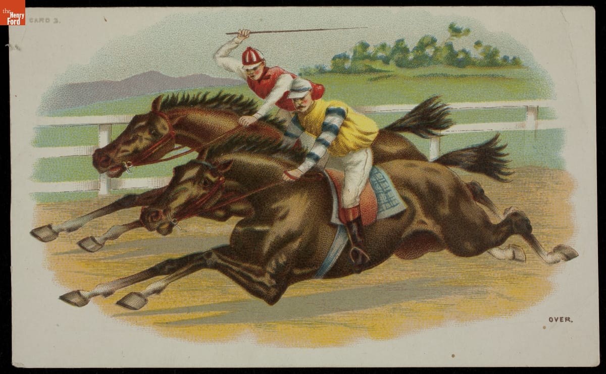 Two jockeys on horses running on a racetrack