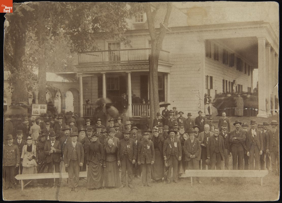 Members of the Grand Army of the Republic (G.A.R.) Visiting Mount Vernon, September 21, 1892 Sepia-toned photo of a large group of men and women in 19th-century clothing standing in front of a two-story wooden house with large porch and columns
