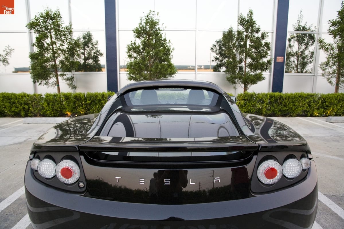 Tesla Car at SpaceX Facility, El Segundo, California, 2008 Back view of low black car parked in lot by building