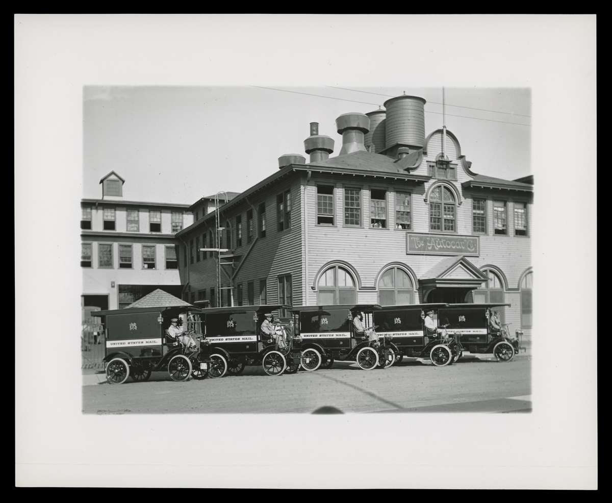 Fleet of Autocar Type XVIII Trucks for U.S. Mail Delivery, Autocar Company Plant, Ardmore, Pennsylvania, circa 1908 Black-and-white photo of small delivery trucks lined up in front of a large brick building