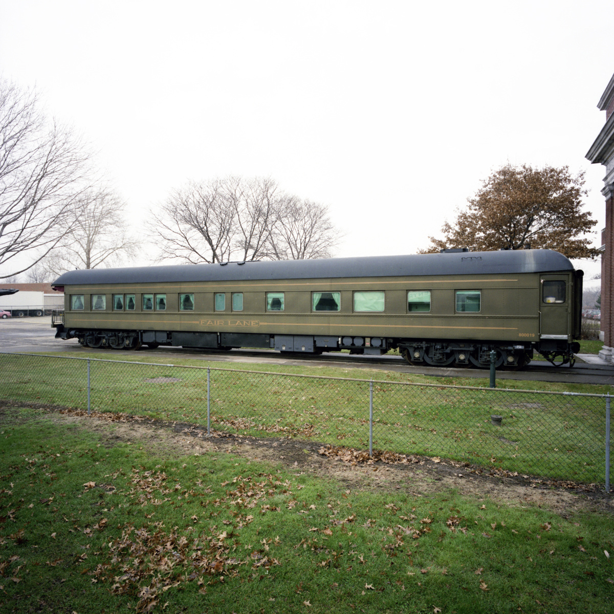 Henry Ford's Private Railroad Car Long, army-green rail car on tracks in a field