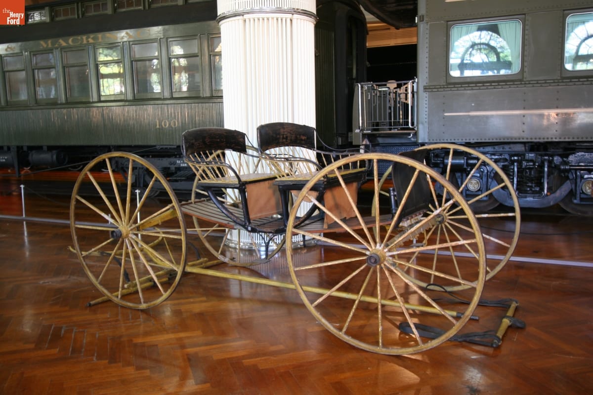 Buckboard Used by the Dr. George E. Woodbury Family, circa 1885 Minimal wooden transport with two seats atop a wooden platform with four large wheels