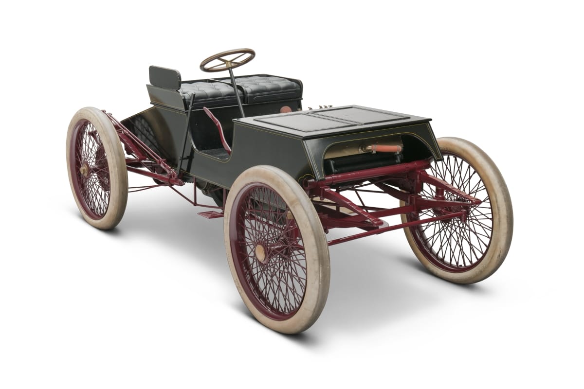 Early open car with four large white wheels